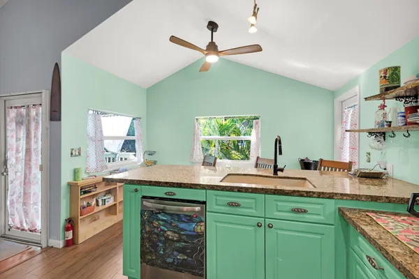 a kitchen with a sink cabinets and wooden floor