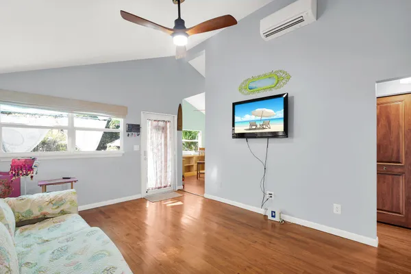 a view of a livingroom with wooden floor and a ceiling fan