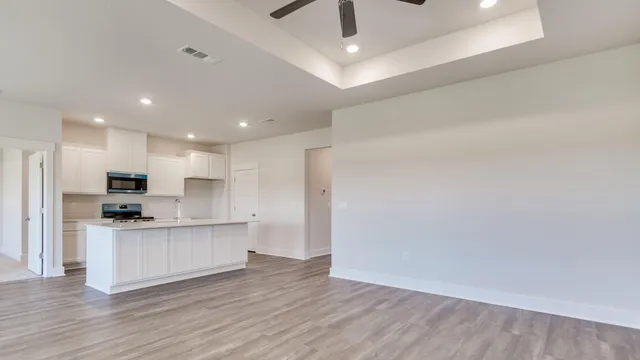 a kitchen with white cabinets and stainless steel appliances