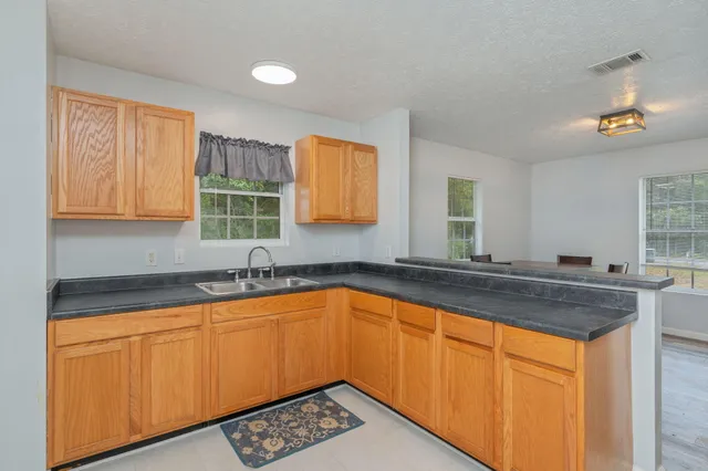 a kitchen with granite countertop sink stove and cabinets