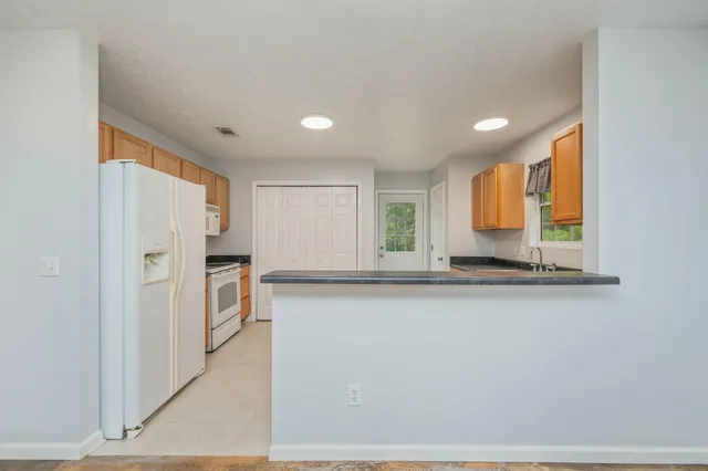a view of a kitchen with stainless steel appliances granite countertop a refrigerator and a sink