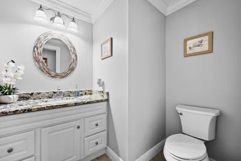 a bathroom with a granite countertop sink toilet a large mirror a shower and vanity