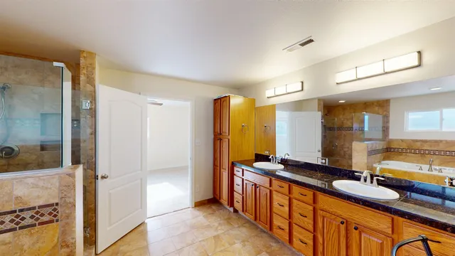 a bathroom with double vanity and a bathtub