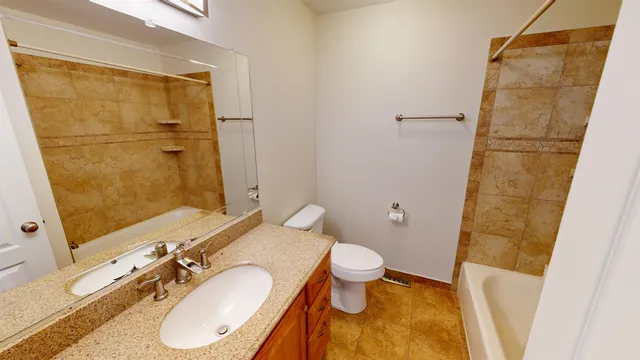 a bathroom with a granite countertop sink toilet and shower