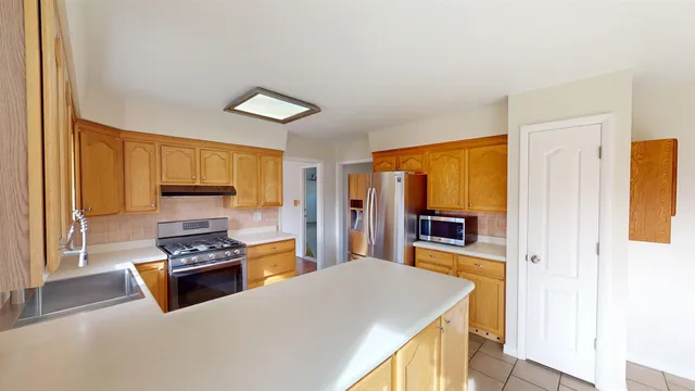 a kitchen with stainless steel appliances granite countertop a stove refrigerator and a microwave