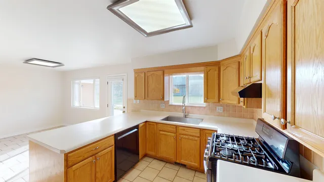 a kitchen with stainless steel appliances granite countertop a sink stove and cabinets