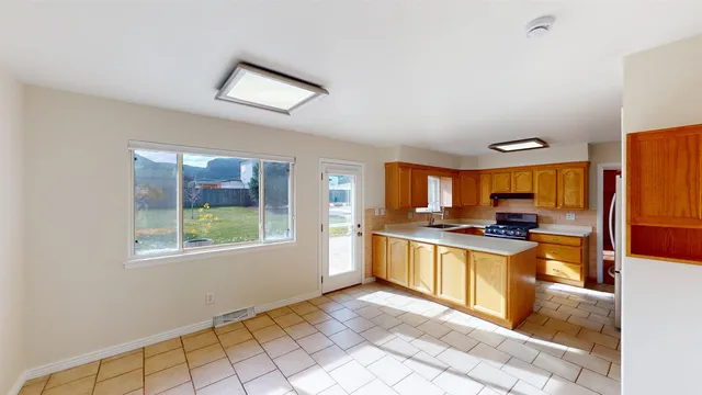 a kitchen with stainless steel appliances granite countertop a stove a sink and a refrigerator