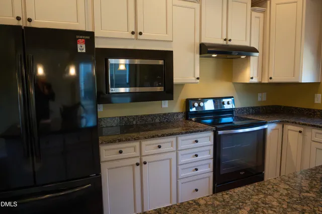 a kitchen with stainless steel appliances granite countertop a stove a microwave and cabinets