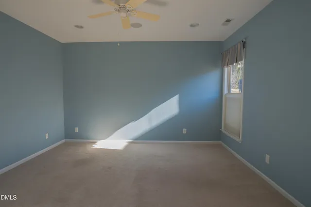 an empty room with a ceiling fan and entryway