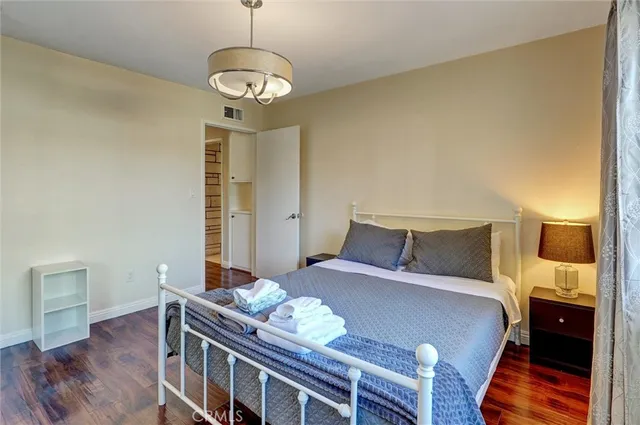 a bedroom with bed and wooden floor