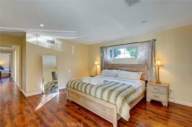 a bedroom with a bed and wooden floor