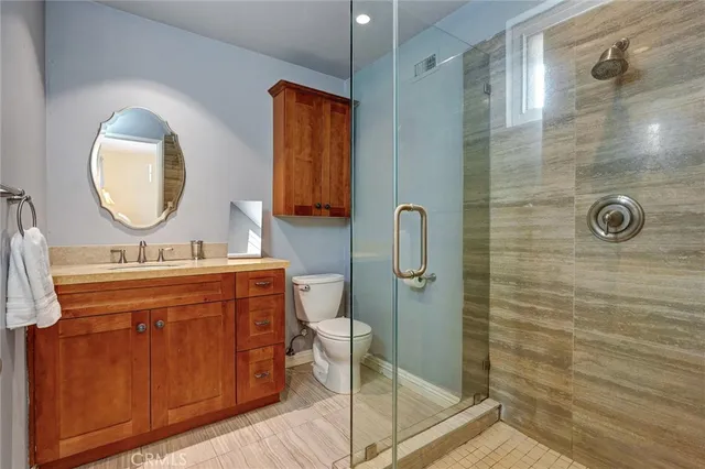 a bathroom with a double vanity sink mirror and shower
