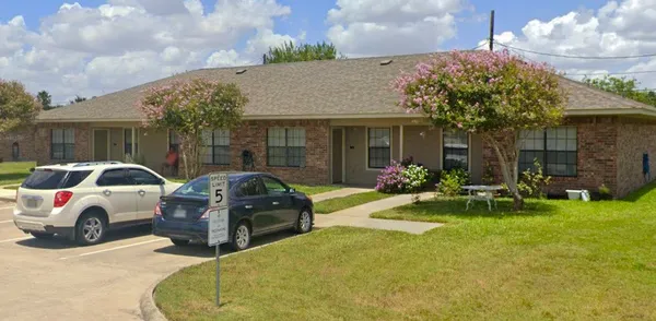 a view of a house with patio area and garden