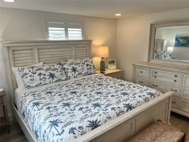 a bed sitting in a bedroom next to a window and dresser