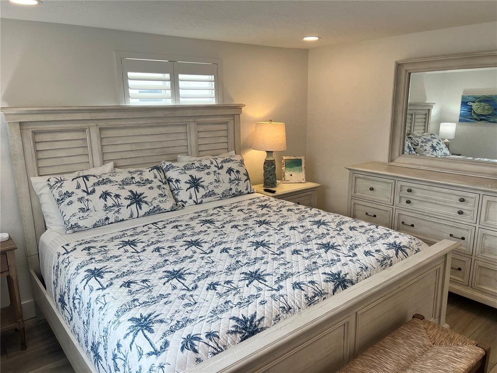 6154 Midnight Pass Road, Unit A15 Sarasota, FL 34242 - Photo 12 of 17 a bed sitting in a bedroom next to a window and dresser