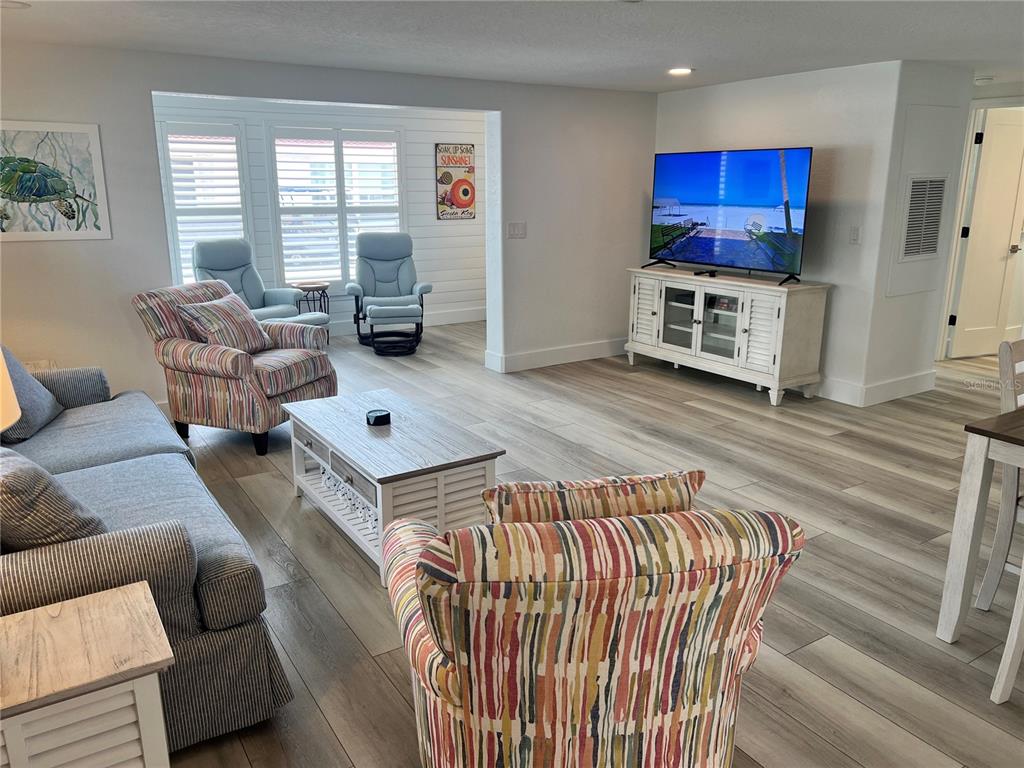 6154 Midnight Pass Road, Unit A15 Sarasota, FL 34242 - Photo 8 of 17 a living room with furniture wooden floor and a fireplace