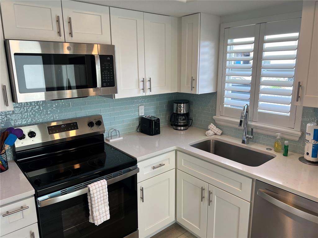 6154 Midnight Pass Road, Unit A15 Sarasota, FL 34242 - Photo 10 of 17 a kitchen with a sink and cabinets