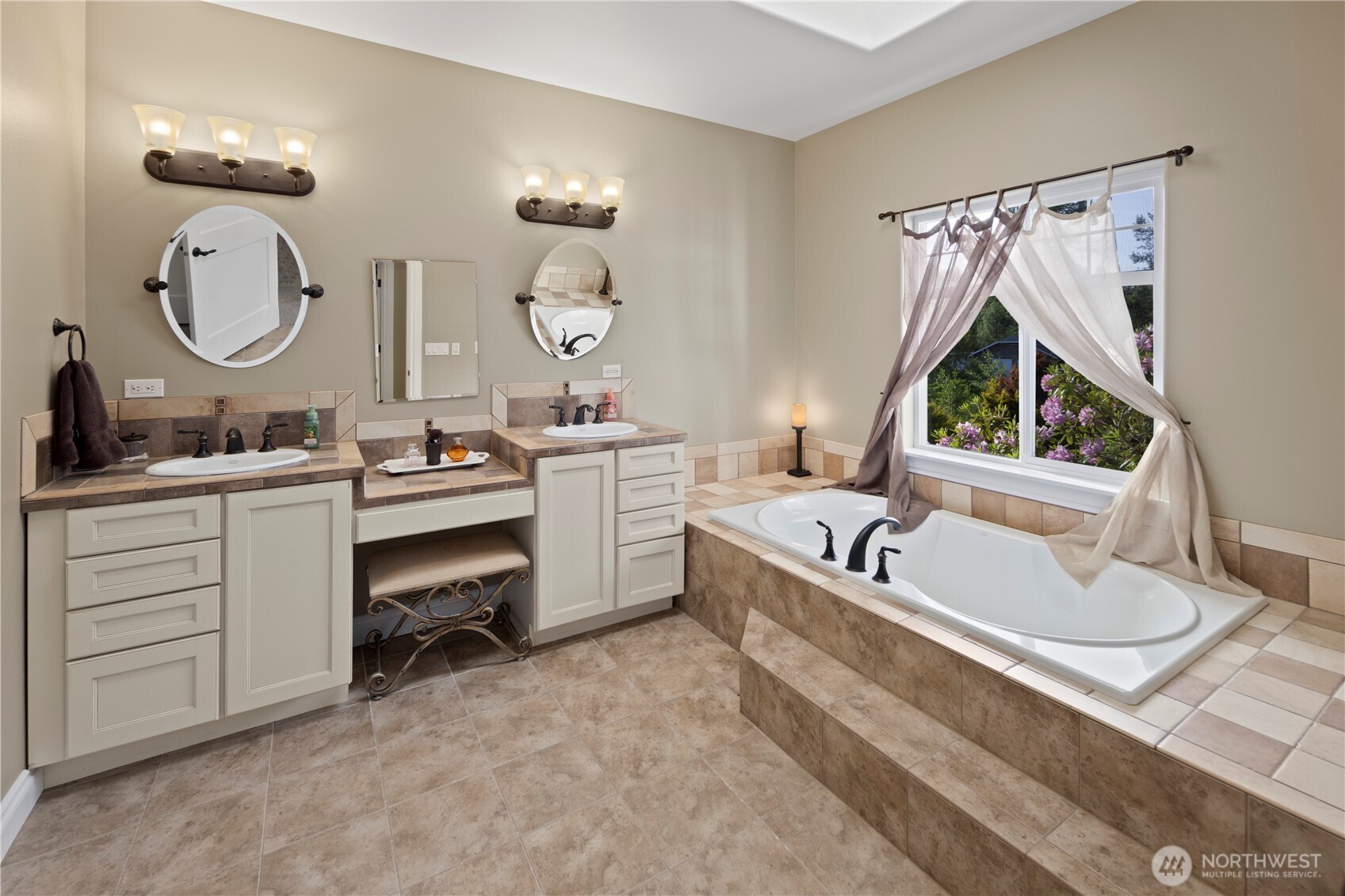 14905 218th Street Southeast Monroe, WA 98272 - Photo 25 of 40 a en suite bathroom with a double vanity sink a mirror a bathtub and a window
