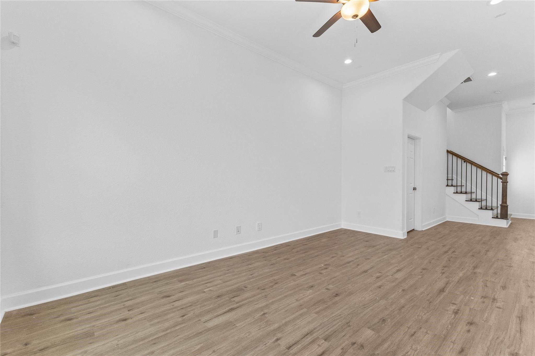 7805 Farnsworth Street, Unit B Houston, TX 77022 - Photo 7 of 26 an empty room with wooden floor ceiling fan and window