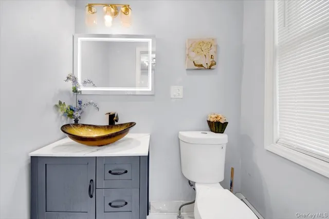 a bathroom with a toilet a sink and mirror