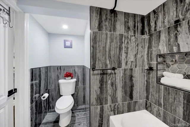 a white toilet sitting next to a bathroom sink and a shower