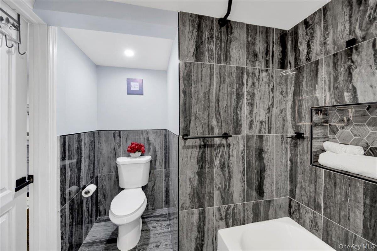 75 West Kingsbridge Road Mount Vernon, NY 10550 - Photo 25 of 37 a white toilet sitting next to a bathroom sink and a shower