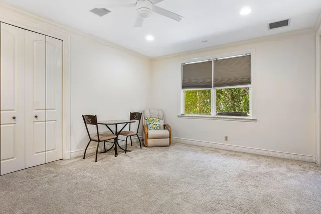 a view of a patio with table and chairs potted plants with floor to ceiling window and potted plants