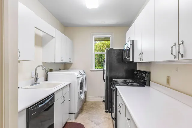 an aerial view of a houses with a garden and lake view