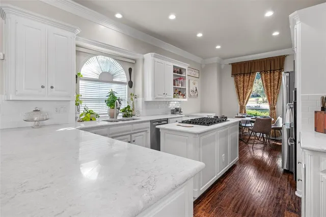 a large white kitchen with wooden floors