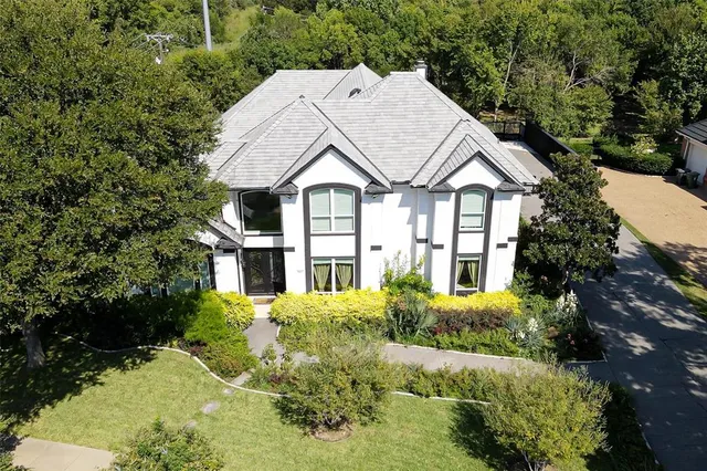 a view of house with garden and tall trees