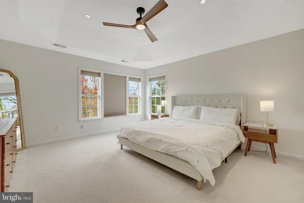 a bedroom with a large bed and wooden floor