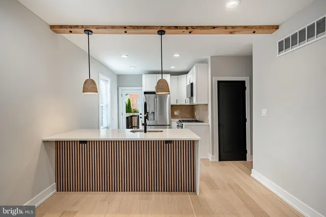 a kitchen with kitchen island a counter top space a sink and refrigerator