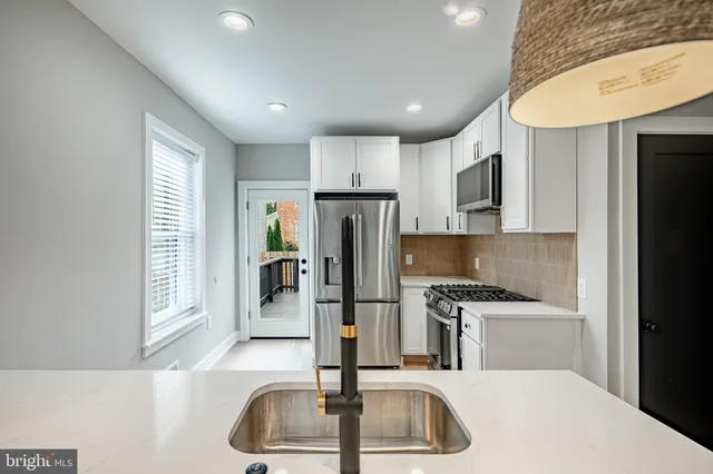 a kitchen with stainless steel appliances granite countertop a refrigerator and a sink
