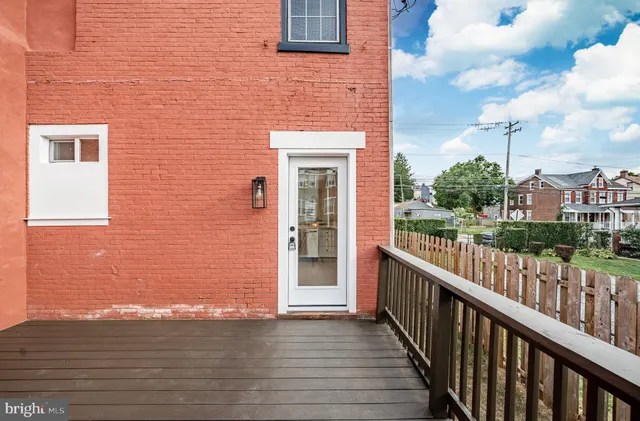 a view of a brick house with a floor to ceiling window and wooden floor