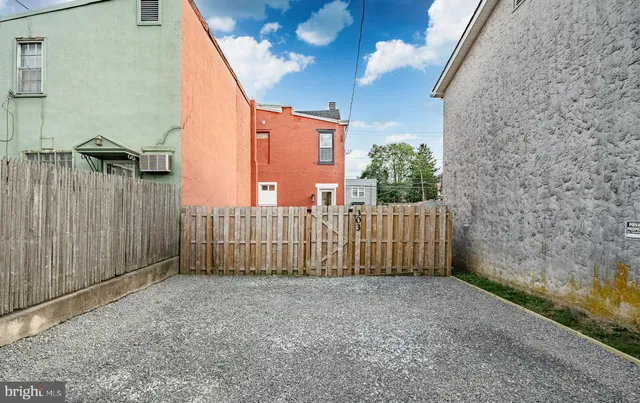 a view of a pathway of a building with wooden fence