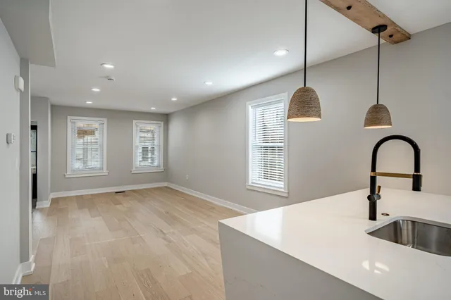 a kitchen with a sink a window and wooden floor