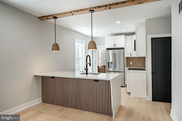 a kitchen with stainless steel appliances granite countertop a refrigerator a oven and a sink with wooden floor