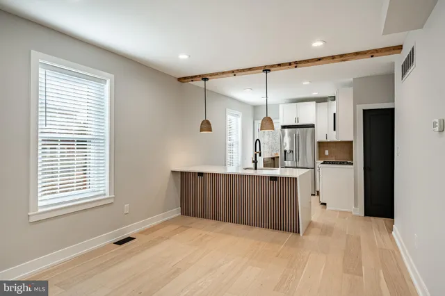 a kitchen with kitchen island a counter top space a sink stainless steel appliances and cabinets
