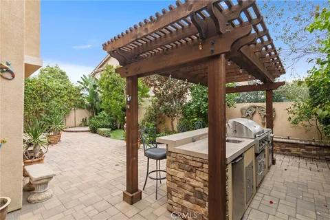 a backyard of a house with a swing chair and potted plants