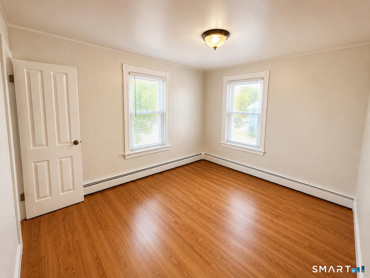 98 Huntington Road Bridgeport, CT 06608 - Photo 12 of 15 an empty room with wooden floor and windows