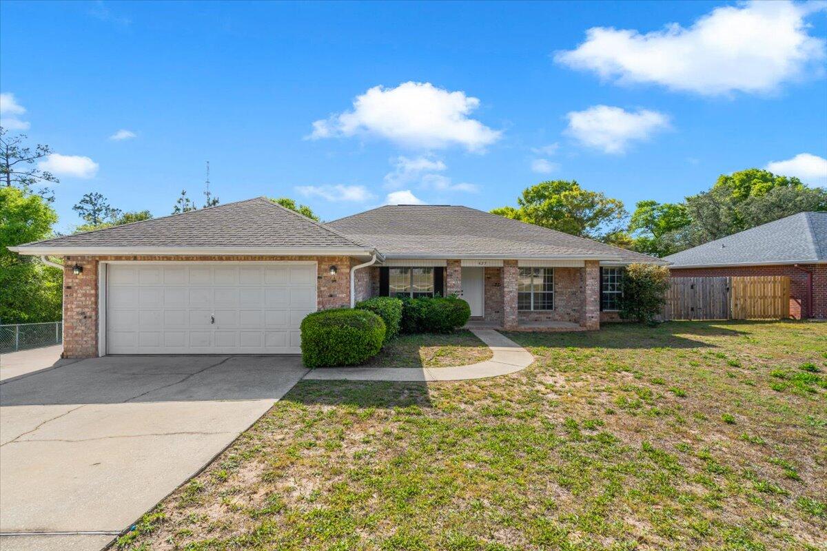 a front view of a house with a yard and potted plants
