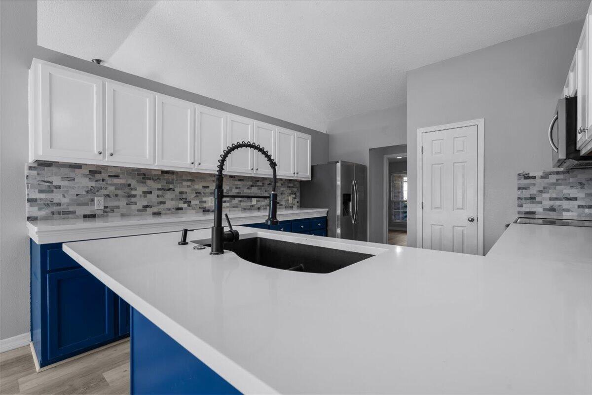 427 Triton Street Crestview, FL 32536 - Photo 11 of 43 a kitchen with stainless steel appliances granite countertop a sink a stove a refrigerator a counter space and cabinets