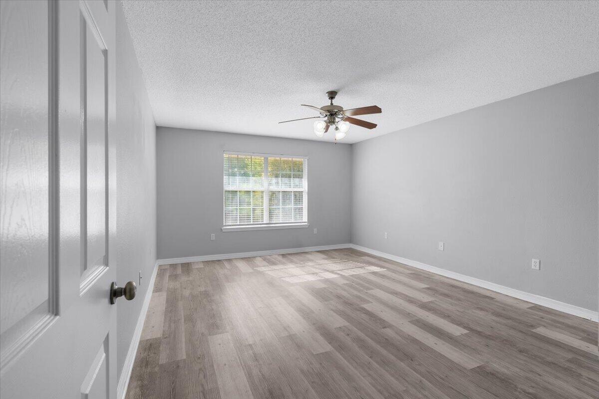 427 Triton Street Crestview, FL 32536 - Photo 18 of 43 wooden floor in an empty room with a window