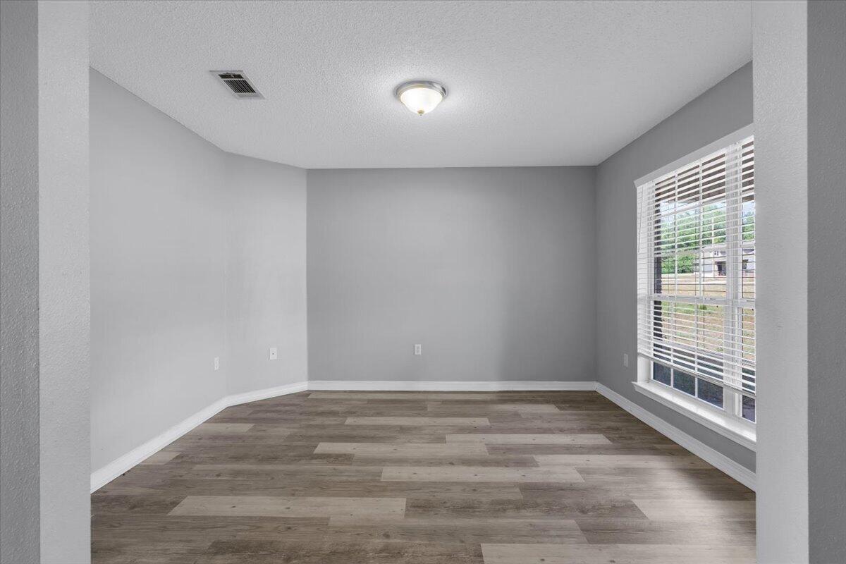 427 Triton Street Crestview, FL 32536 - Photo 4 of 43 a view of an empty room with wooden floor and a window