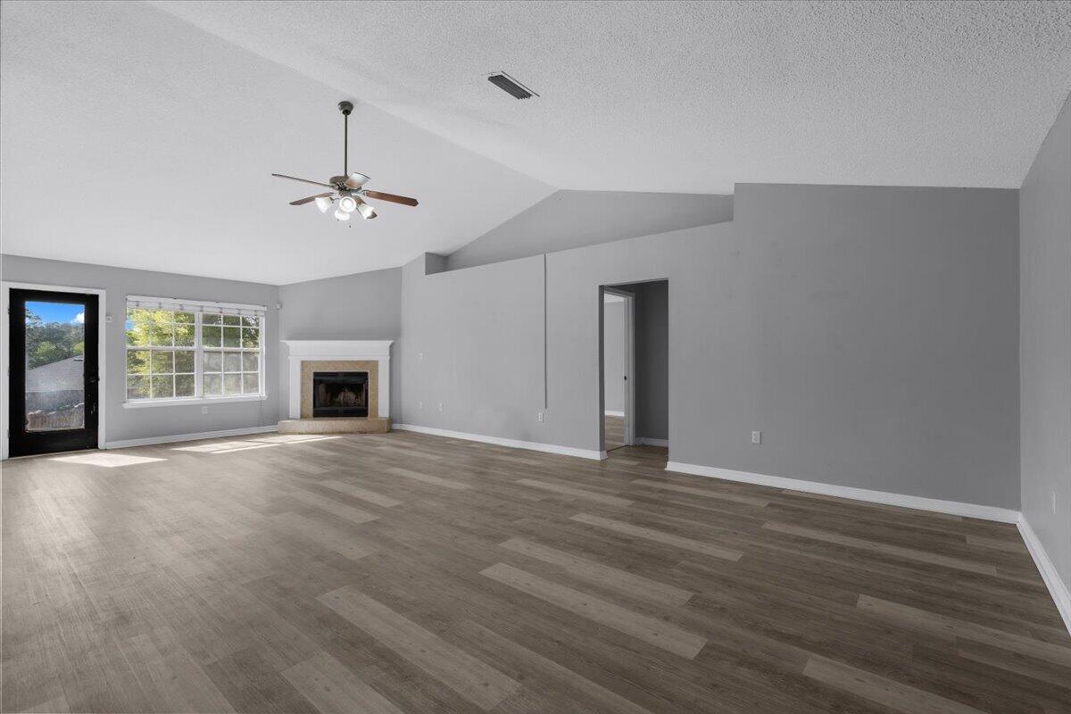 427 Triton Street Crestview, FL 32536 - Photo 7 of 43 a view of an empty room with wooden floor fireplace and a window