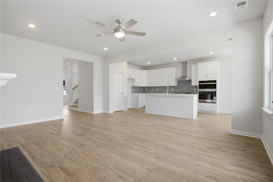 557 Hydrangea Street, Unit LOT 46 Seneca, SC 29678 - Photo 37 of 37 An open floorplan seamlessly connects the kitchen and living areas, offering effortless movement and abundant light.