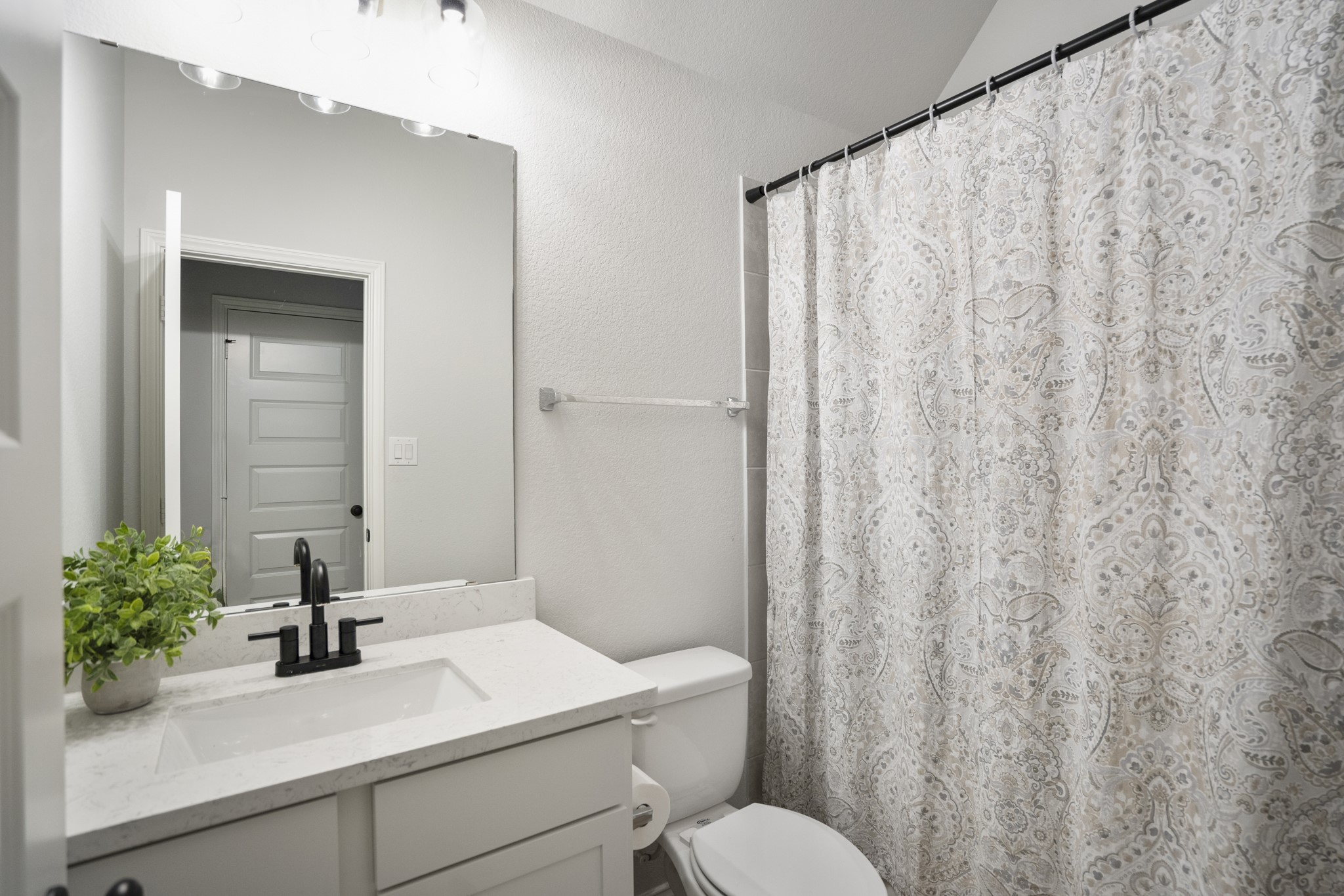 334 Topper Pines Drive Montgomery, TX 77316 - Photo 28 of 49 Between the two secondary bedrooms, the full bath keeps the hallway layout simple with a single vanity, cabinet storage below, and a tub/shower combo just beyond the curtain.