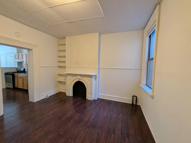 a view of a livingroom with wooden floor and a ceiling fan