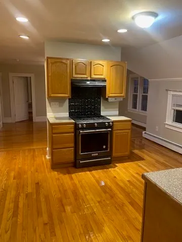a kitchen with kitchen island a stove a sink and a microwave