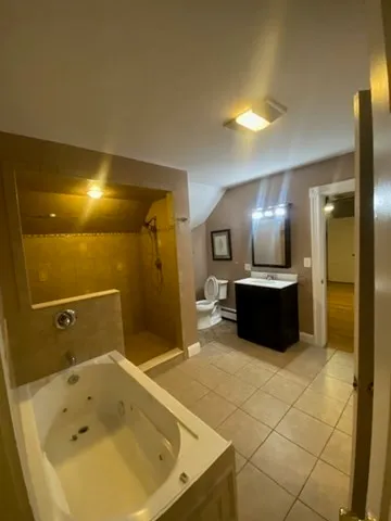 a bathroom with a tub a sink and a mirror